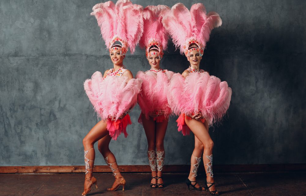 Three Women in cabaret costume with pink feathers plumage.